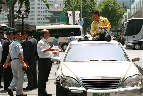  지난 2006년 11일 오후 서울 태평로 삼성 본관 앞에서 차를 주차해놓고 시위를 벌이던 김경환씨가 자장면으로 점심을 먹은 뒤 삼성 관계자들과 대화를 나누고 있다.